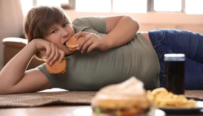 menino-com-excesso-de-peso-com-fast-food-em-casa_495423-55501